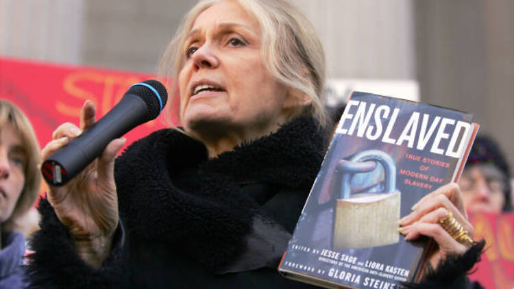 Feminist and author Gloria Steinem holds up a copy of her book "Enslaved"