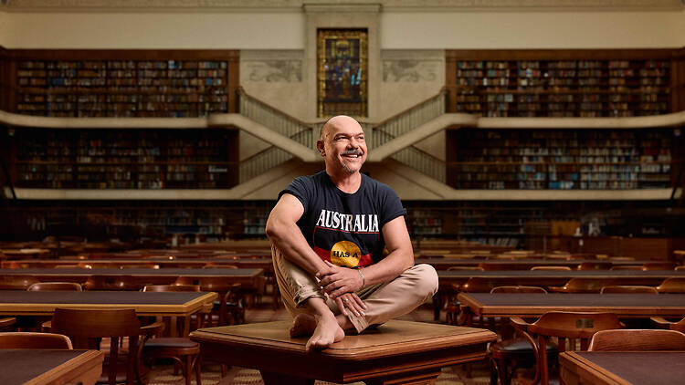 man sits on a table in a library
