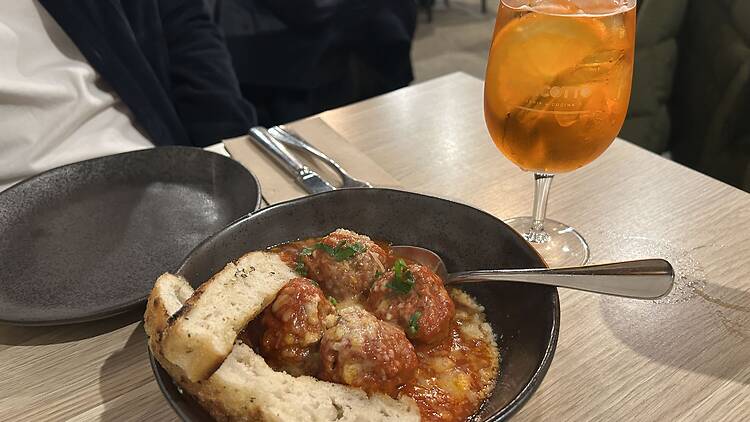 A bowl of meatballs and an Aperol Spritz.