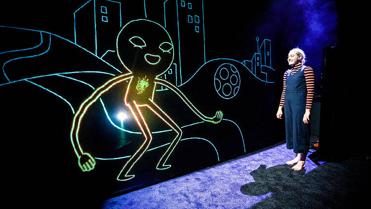 ZOOOM: Wild Things International Kids Festival woman looks at lit up line drawing