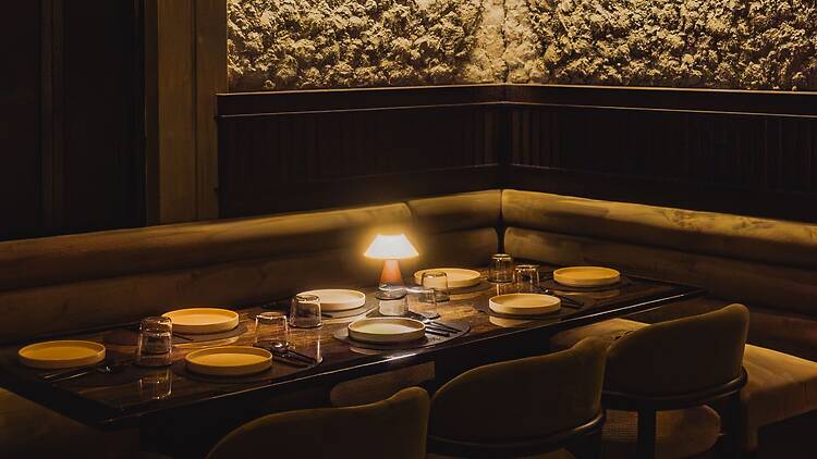 The dining space in Selva goes the suave route of dim lamps and long tables