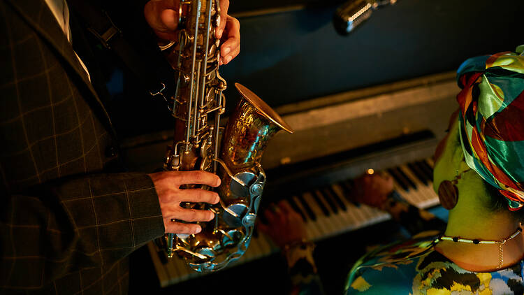 Male Saxophonist Playing Music while Accompanying Piano in Jazz Club Live jazz