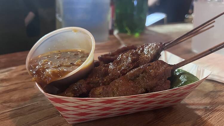 Beef satay in a paper boat