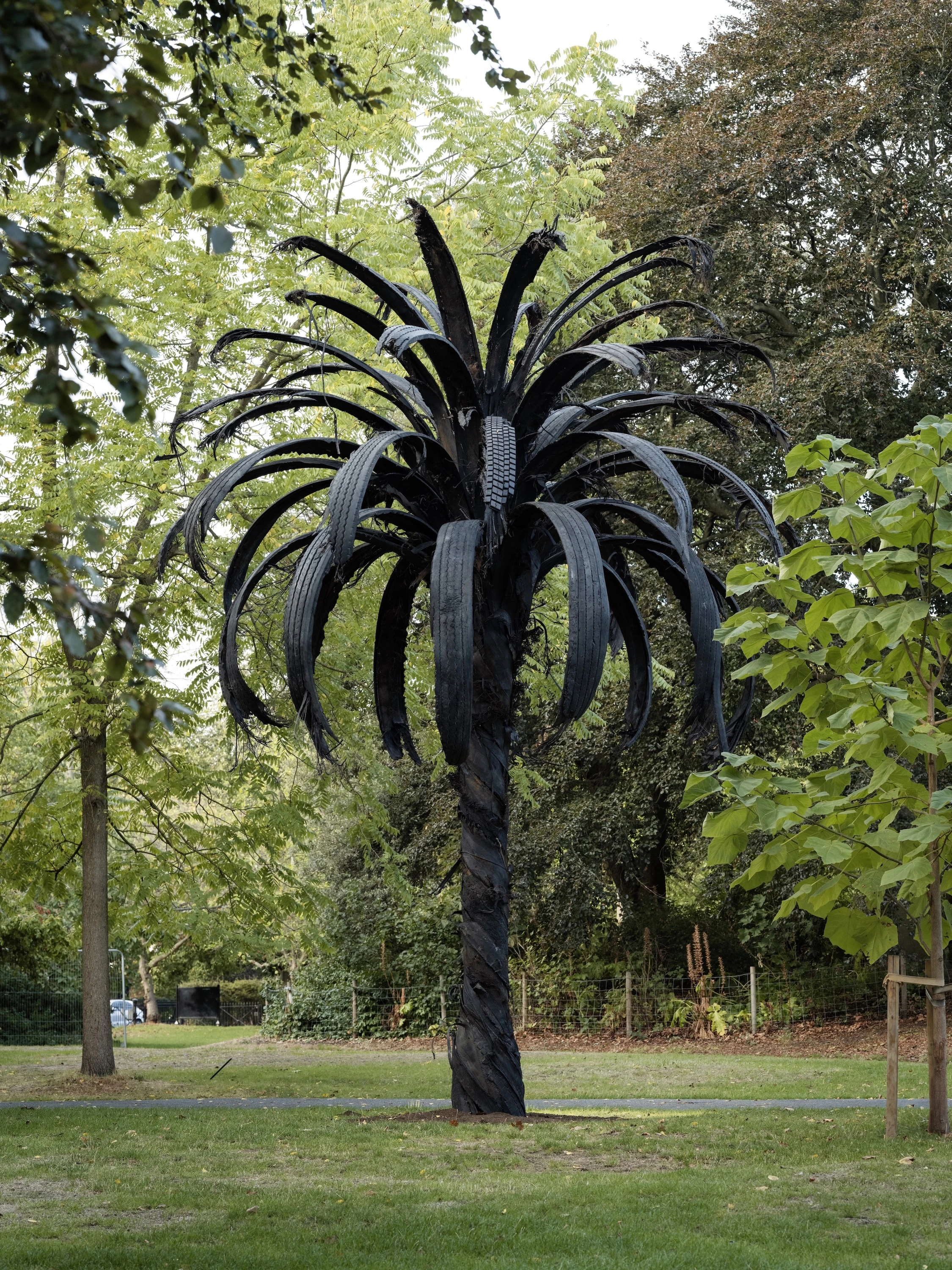 Black palm tree sculpture made from tryes and steel