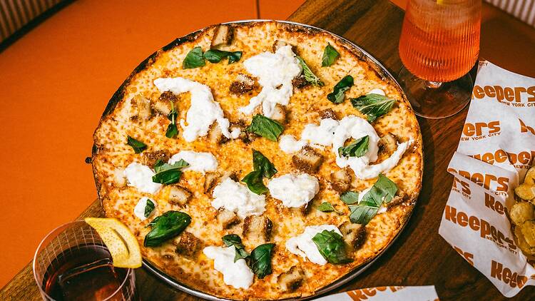 A pizza with cheese and basil on it