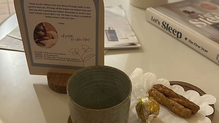 A cup of tea and chocolate on a table.