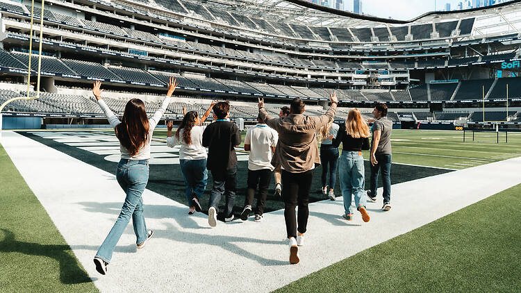 Tour members running onto the SoFi Stadium field