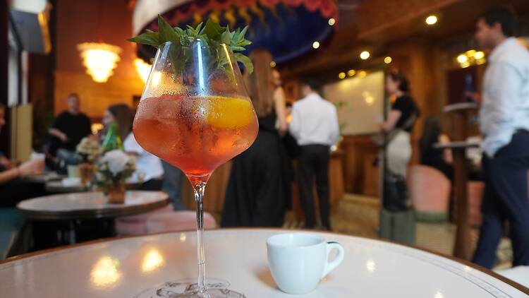 The deconstructed tonic in a wine glass with herbs and lemon