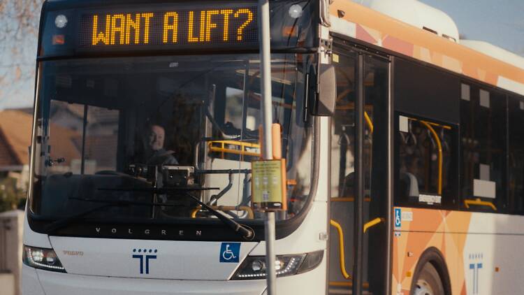 A Transport Vic bus arriving at a bus stop