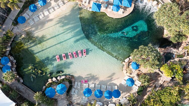 hotel pools shot from above – with people doing pilates on floating mats