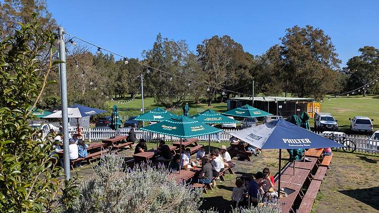  A beer garden with umbrellas and trees around