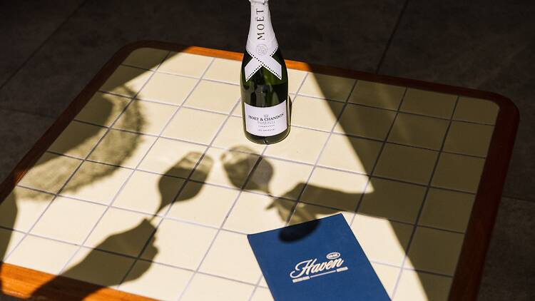 Moet Ice x Pharrell Williams A bottle of Moet Ice x Pharrell Williams with shadows of glasses cheering in front of it
