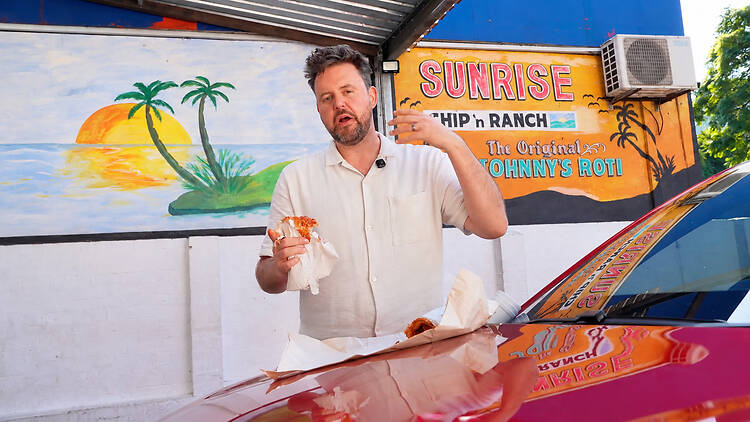 A paper-wrapped roti and a car bonnet: lunch the Johnny’s way.
