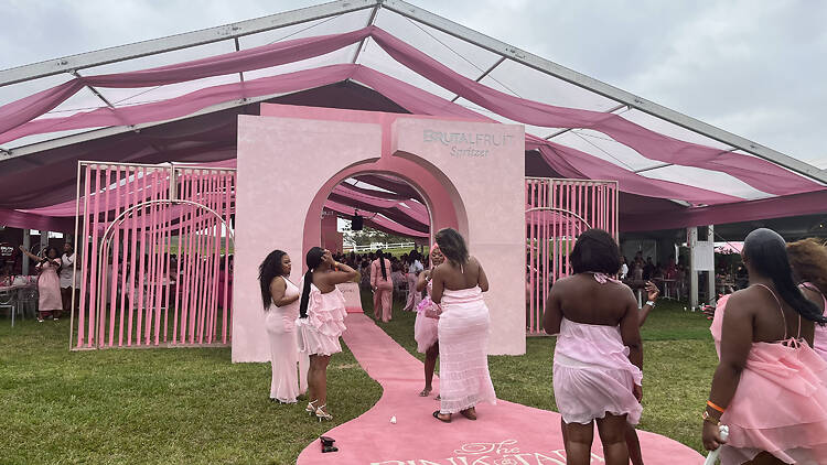 Dressed for the occasion, guests gather at the Pink Table’s entrance. Dressed for the occasion, guests gather at the Pink Table’s entrance.