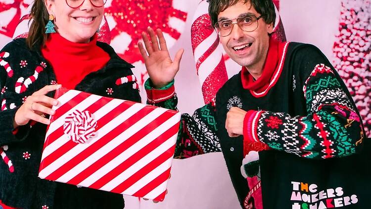 woman and man pose with christmas gifts and background