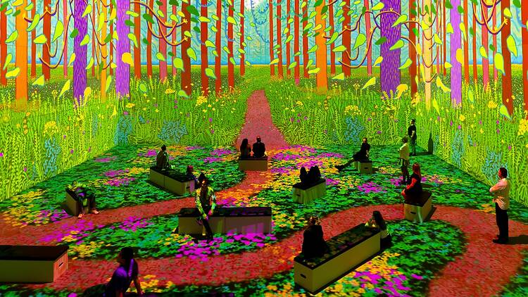 David Hockney: Bigger & Closer (not smaller & further away) people sitting to see colourful art of trees and gardens