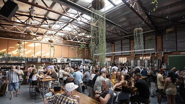 Mixtape Brewing people sitting inside a spacious beer brewery drinking beer
