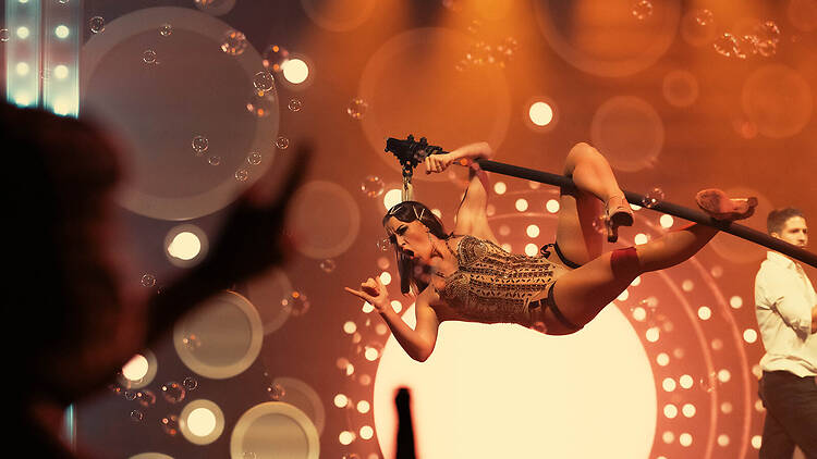 Blanc de Blanc Encore Show female aerialist hangs from pole