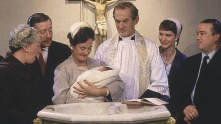 A still from the film Distant Voices, Still Lives of a baby being christened at a font 