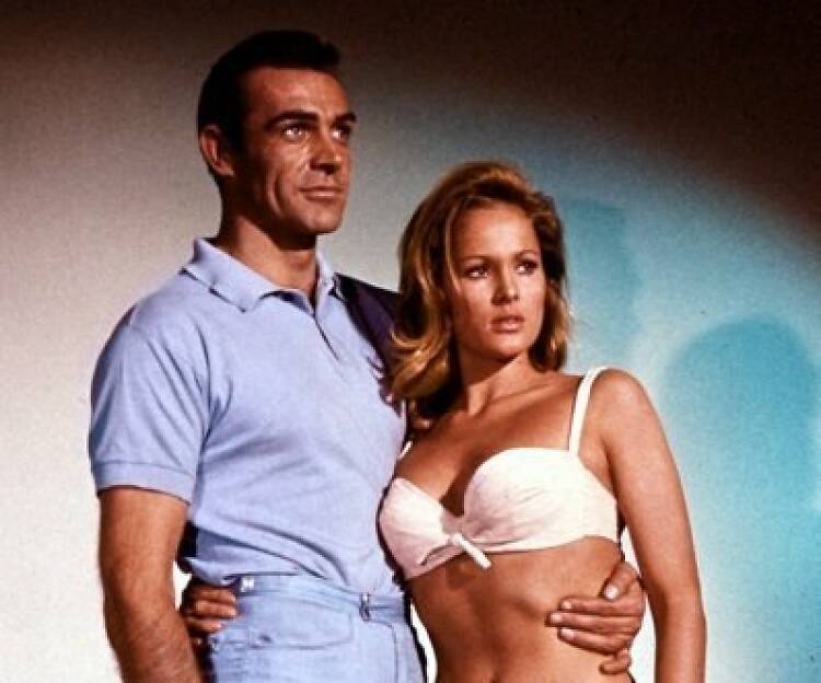 Still from the film Dr No of Sean Connery as James Bond hugging Ursula Andress