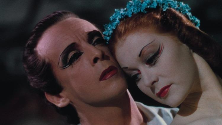 A still from the film The Red Shoes of a man and woman in make-up embracing