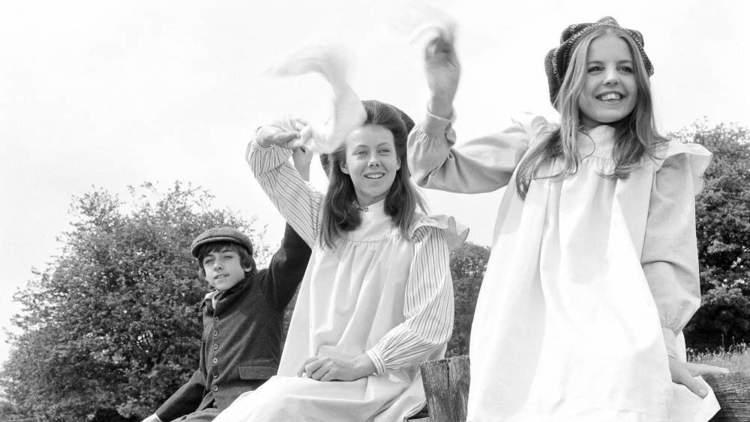 A still from The Railway Children with the three children waving